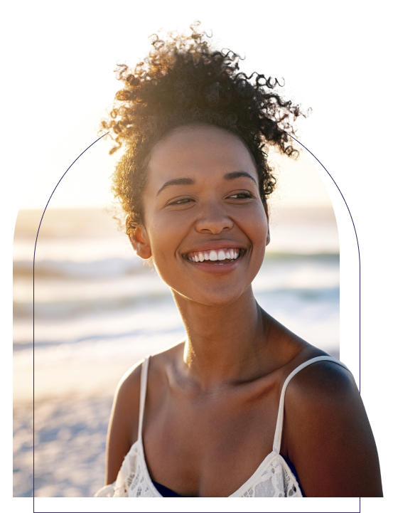 A young African-American girl smiling and looking refreshed on the beach.