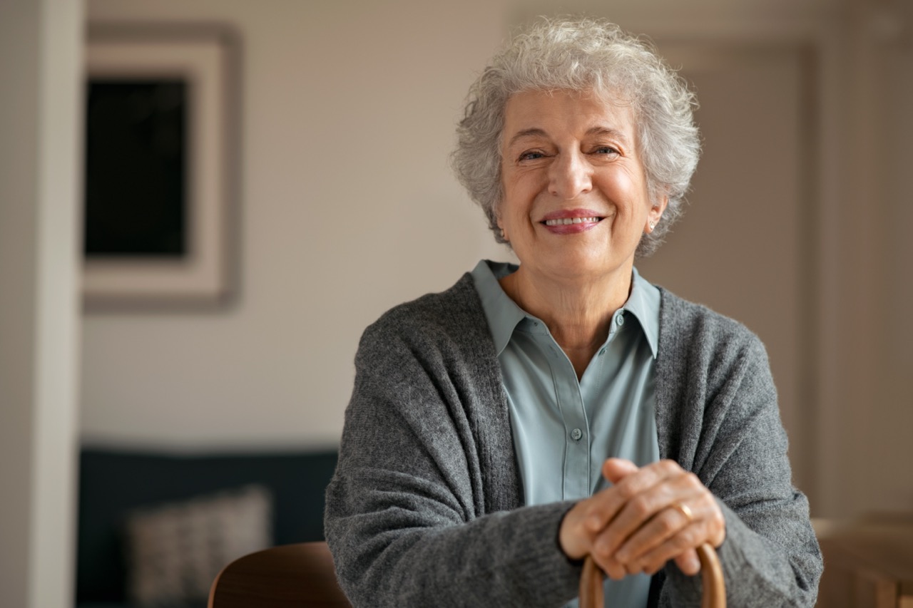 older woman in her 60s smiling at the camera